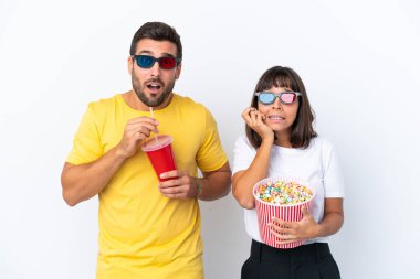 Beyaz arka planda 3 boyutlu gözlüklü ve elinde patlamış mısırla yaşayan genç bir çift.