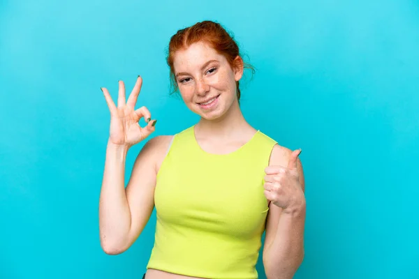 Young Reddish Woman Isolated Blue Background Showing Sign Thumb Gesture — Fotografia de Stock