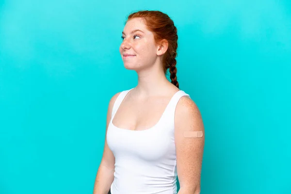 Young Reddish Woman Wearing Band Aids Blue Background Looking While — стоковое фото