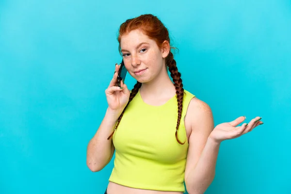 Young Reddish Woman Isolated Blue Background Keeping Conversation Mobile Phone — Fotografia de Stock