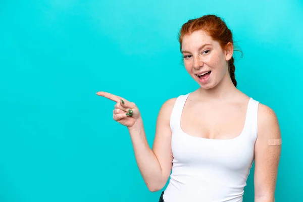 Young Reddish Woman Wearing Band Aids Blue Background Surprised Pointing — Stok fotoğraf