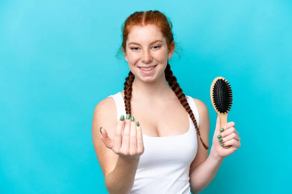 Young Caucasian Reddish Woman Hair Comb Isolated Blue Background Inviting — Foto Stock
