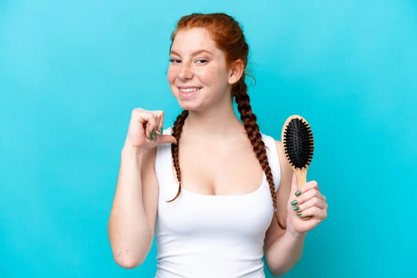 Young Caucasian Reddish Woman Hair Comb Isolated Blue Background Proud — Φωτογραφία Αρχείου