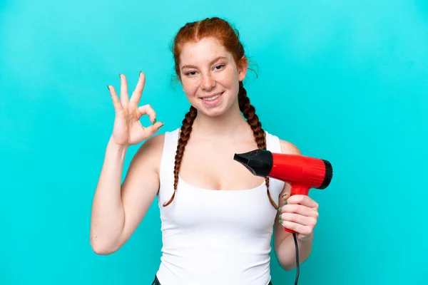 Young Caucasian Reddish Holding Hairdryer Isolated Blue Background Showing Sign — Stok fotoğraf
