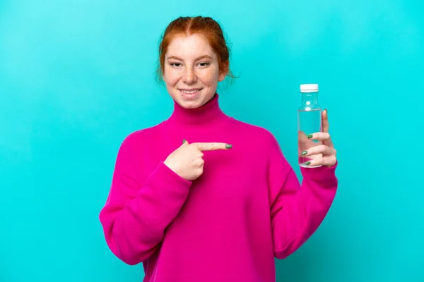 Young Caucasian Reddish Woman Bottle Water Isolated Blue Background Pointing — Stockfoto
