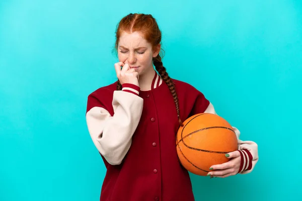 Mladá Načervenalá Žena Hraje Basketbal Izolované Modrém Pozadí Pochybnostmi — Stock fotografie