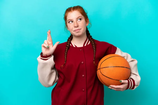 Young Reddish Woman Playing Basketball Isolated Blue Background Fingers Crossing —  Fotos de Stock