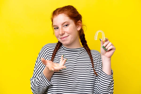 Young Caucasian Reddish Woman Holding Invisible Braces Isolated Yellow Background — Foto de Stock