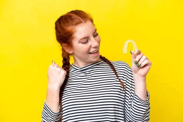 Young Caucasian Reddish Woman Holding Invisible Braces Isolated Yellow Background —  Fotos de Stock