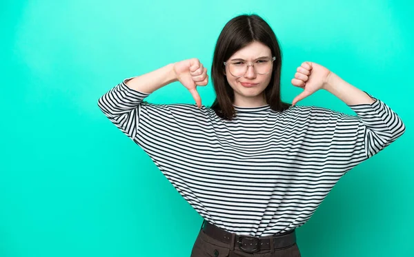 Young Russian Woman Isolated Green Background Showing Thumb Two Hands — стоковое фото