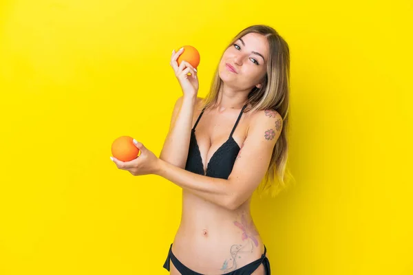 루마니아 여자가 수영복을 채노란 배경에 고립되어 오렌지를 — 스톡 사진