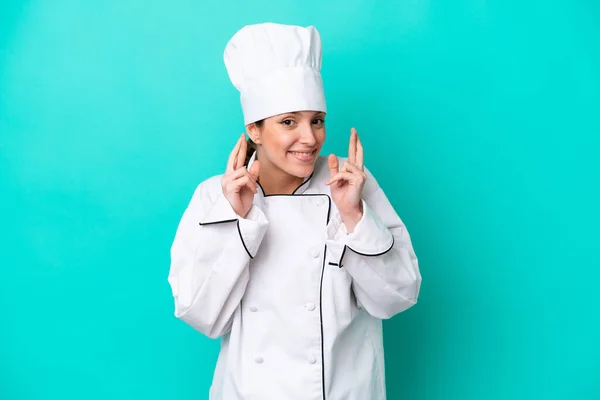 Young Caucasian Chef Woman Isolated Blue Background Fingers Crossing — стоковое фото