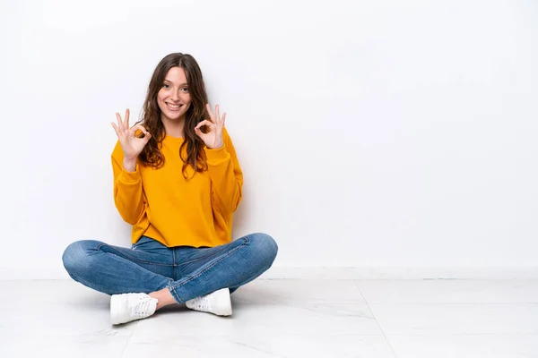 Young Caucasian Woman Sitting Floor Isolated White Wall Showing Sign — Fotografia de Stock