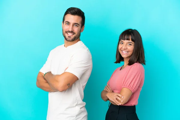 Young Couple Isolated Blue Background Keeping Arms Crossed Lateral Position — Foto de Stock