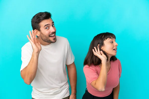 Jong Paar Geïsoleerd Blauwe Achtergrond Luisteren Naar Iets Door Het — Stockfoto