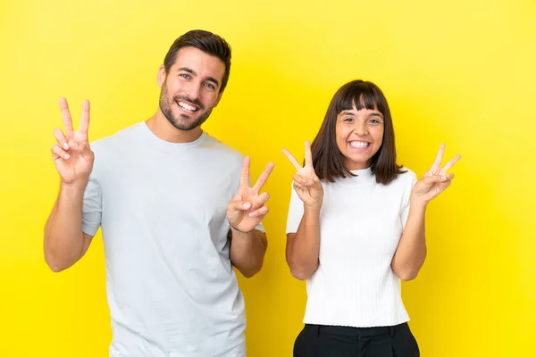 Young Couple Isolated Yellow Background Smiling Showing Victory Sign Both — ストック写真
