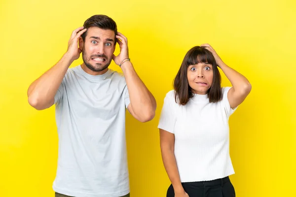 Young Couple Isolated Yellow Background Takes Hands Head Because Has — ストック写真