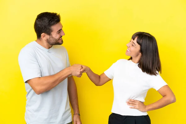 Young Couple Isolated Yellow Background Handshaking Good Deal — 图库照片