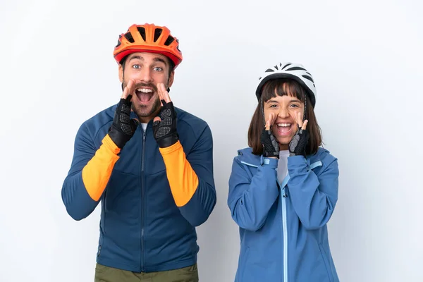 Young Cyclist Couple Isolated White Background Shouting Announcing Something — Stock Fotó