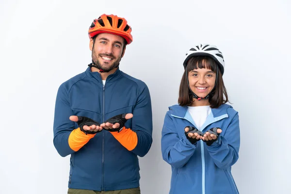 Young Cyclist Couple Isolated White Background Holding Copyspace Imaginary Palm — Stock Fotó