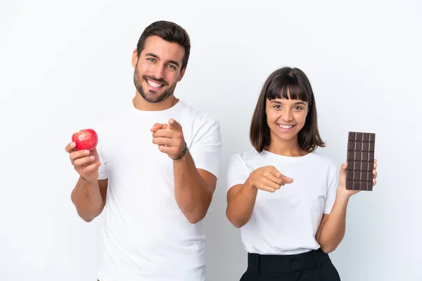 Young Couple Holding Chocolate Apple Isolated White Background Points Finger —  Fotos de Stock