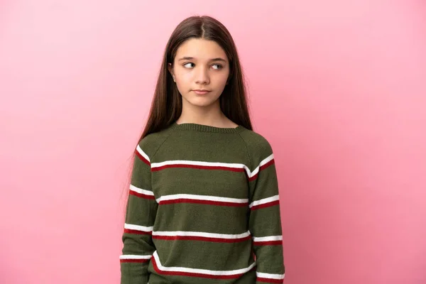 Klein Meisje Geïsoleerde Roze Achtergrond Maken Twijfels Gebaar Kijken Kant — Stockfoto