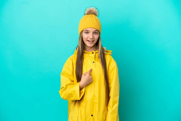 Κοριτσάκι Που Φοράει Αδιάβροχο Παλτό Πάνω Από Απομονωμένο Μπλε Φόντο — Φωτογραφία Αρχείου