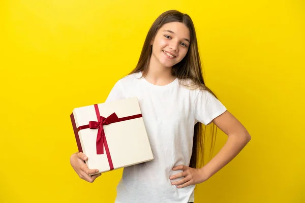 Little Girl Holding Gift Isolated Yellow Background Posing Arms Hip — Stockfoto