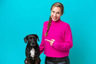 Köpeğiyle birlikte mavi arka planda izole edilmiş beyaz bir kadın.