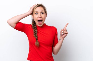 Beyaz arka planda izole edilmiş genç beyaz kadın şaşırmış ve işaret ediyor.