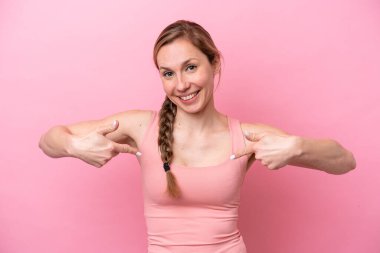 Genç beyaz kadın pembe arka planda soyutlanmış gururlu ve kendini beğenmiş.