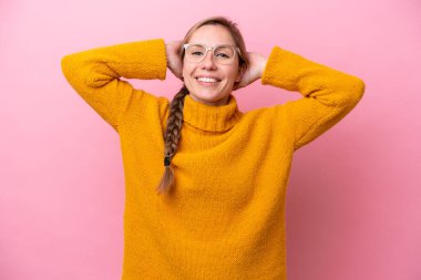 Pembe arka planda izole edilmiş genç beyaz kadın gülüyor.