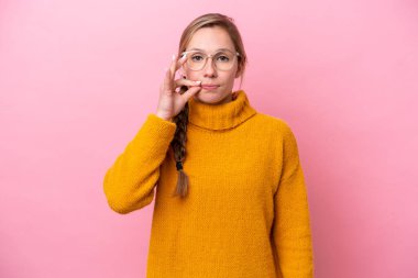 Pembe arka planda izole edilmiş beyaz bir kadın sessizlik işareti gösteriyor.