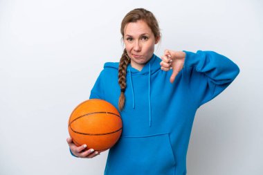 Beyaz arka planda basketbol oynayan beyaz tenli genç bir kadın olumsuz bir ifadeyle baş parmağını aşağı gösteriyor.
