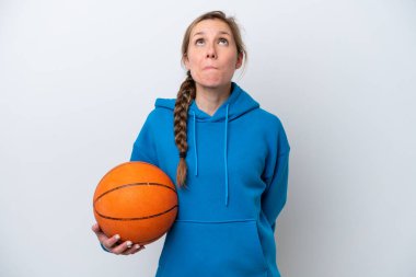 Basketbol oynayan beyaz tenli genç bir kadın beyaz arka planda izole edilmiş ve yukarı bakıyor.