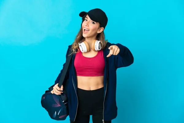 Young Sport Woman Sport Bag Isolated Blue Background Surprised Pointing — Φωτογραφία Αρχείου