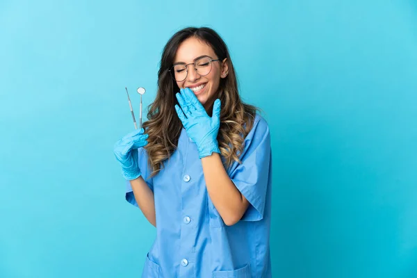 Zahnärztin Hält Werkzeuge Über Isoliert Auf Blauem Hintergrund Glücklich Und — Stockfoto