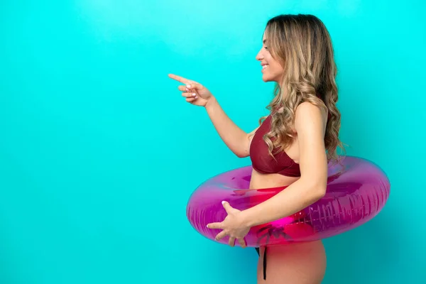 Woman Swimsuit Holding Floater Isolated Blue Background Pointing Side Present — ストック写真