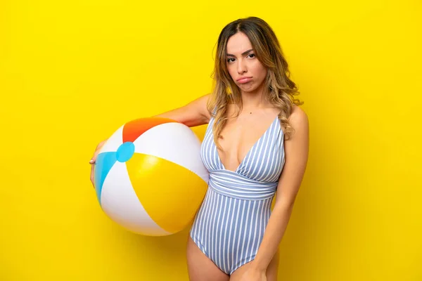 Young Woman Holding Beach Ball Isolated Yellow Background Sad Expression — Stockfoto