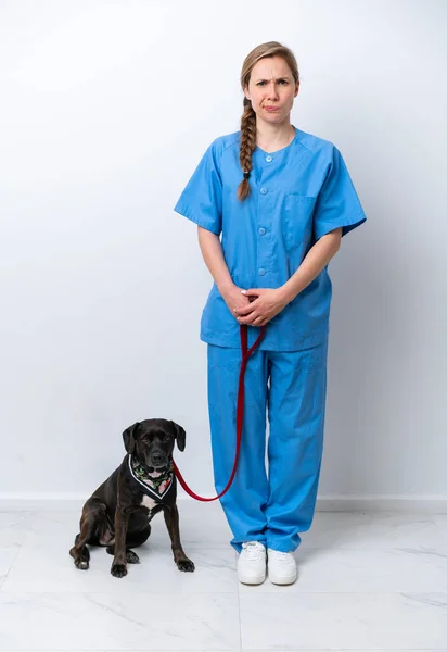 Full body veterinarian woman with a dog isolated on white background with sad expression