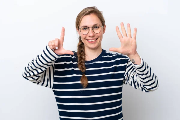 Beyaz arka planda izole edilmiş genç beyaz kadın parmaklarıyla yediyi saydı