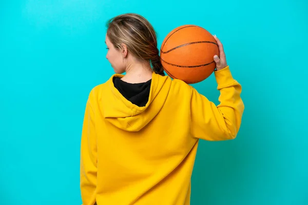 Jonge Kaukasische Vrouw Geïsoleerd Blauwe Achtergrond Spelen Basketbal Achterste Positie — Stockfoto