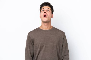 Beyaz fırında izole edilmiş yakışıklı beyaz adam yukarı bakıyor ve şaşırmış bir ifadeyle