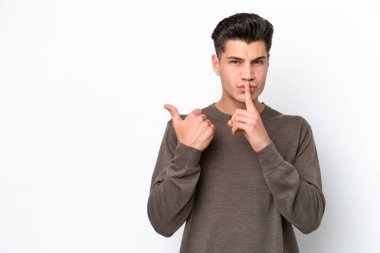 Beyaz fırında soyutlanmış yakışıklı beyaz bir adam yan tarafı gösterip sessiz hareketler yapıyor.