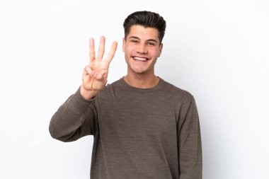 Beyaz fırında izole edilmiş yakışıklı beyaz adam mutlu ve parmaklarıyla üçe kadar sayıyor.