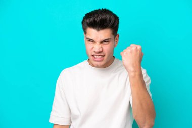 Genç yakışıklı beyaz adam mutsuz bir ifadeyle mavi fırında izole edilmiş.