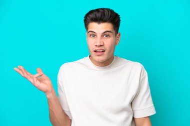 Genç, yakışıklı, beyaz bir adam, mavi fırında izole edilmiş, şüpheli hareketler yapıyor.