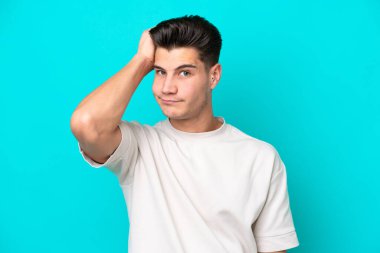 Genç, yakışıklı, beyaz bir adam mavi bir bakkalda izole edilmiş, hayal kırıklığı dolu ve anlamayan bir ifadeyle.