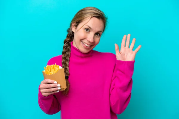 Young Caucasian Woman Holding Fried Chips Isolated Blue Background Saluting — ストック写真