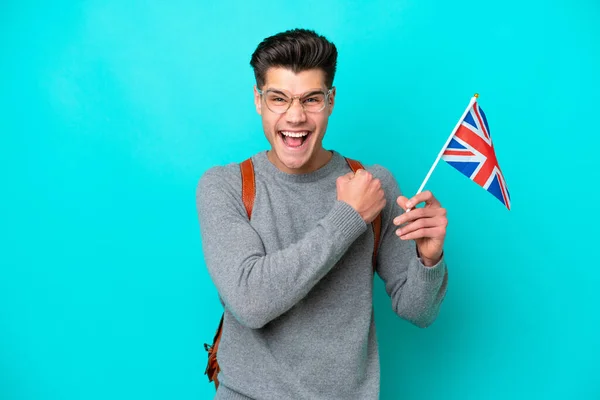 勝利を祝う青の背景に隔離された英国の旗を持っている若い白人男性 — ストック写真